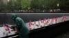 Una persona coloca unas flores frente al monumento en honor a las víctimas del 11 de septiembre de 2001 en el World Trade Center de Nueva York, en vísperas del aniversario 22, el 10 de septiembre de 2023.