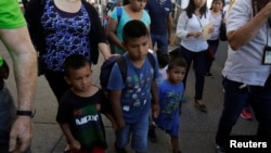 ក្រុម​គ្រួសារ​ពី​ប្រទេស​ម៉ិកស៊ិក​ ដែល​រត់​គេច​ពី​អំពើ​ហិង្សា​ដើរ​សំដៅ​ទៅ​សហរដ្ឋ​អាមេរិក ដើម្បី​ជួប​មន្ត្រី​នៅ​​ទី​ភ្នាក់ងារ​គយ និង​ការ​ពារ​ព្រំ​ដែន ដើម្បី​ដាក់​ពាក្យ​ស្នើ​សុំ​សិទ្ធិ​​ជា​ជន​ភៀស​ខ្លួន​ នៅ​ក្រុង Ciudad Juarez កាល​ពី​ថ្ងៃ​ទី​២០ មិថុនា ២០១៨។