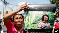 A woman holds up a poster with a photo of slain environmental leader Berta Caceres, during a protest march in Tegucigalpa, Honduras, March 16, 2016. Authorities said unidentified gunmen killed Nelson Garcia, a colleague of Caceres, on March 15.
