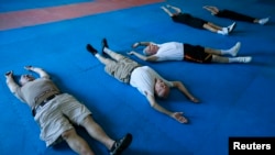 FILE - Parkinson's patients stretch as they begin their workout in Costa Mesa, California, Sept. 16, 2013. Scientists have used "reprogrammed" stem cells to restore functioning brain cells in monkeys, raising hopes the technique could be used in Parkinson's patients.