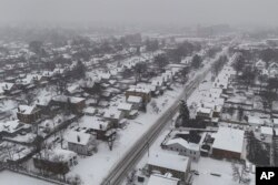 Salju menutupi rumah-rumah selama badai musim dingin, Senin, 6 Januari 2025, di Cincinnati. (Joshua A. Bickel/AP)