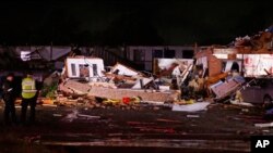Police stand at the ruins of a hotel in El Reno, Okla., May 26, 2019, following a likely tornado touchdown late Saturday night.