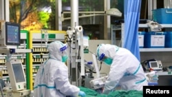 Madaktari wakiwa na mavazi ya kujikinga wakimtibu mgonjwa mwenye homa ya mapafu iliyosabibishwa na kirusi corona katika hospitali ya Zhongnan ya Chuo Kikuu cha Wuhan