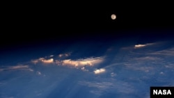 FILE - Expedition 48 Commander Jeff Williams of NASA took this photograph on June 21, 2016, from the International Space Station, writing, "A spectacular rise of the full moon just before sunset while flying over western China."