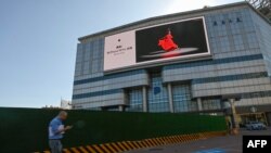 Un hombre pasa junto a un anuncio del iPhone de Apple en Beijing el 12 de septiembre de 2023. (Foto de Pedro PARDO / AFP)