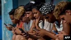 FILE - Young people use a hotspot to connect to the internet, in Havana, Cuba, June 06, 2019. 