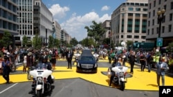 The hearse with the flag-draped casket of Rep. John Lewis, D-Ga., drives on 16th Street, renamed Black Lives Matter Plaza, near the White House, July 27, 2020.