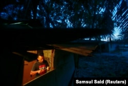 Pekerja Indonesia Abdul Rahim Gani, 32, memotong buah di rumahnya dekat perkebunan kelapa sawit di Felda Bukit Cerakah di distrik Klang, di luar Kuala Lumpur, 16 April 2014. (Foto: REUTERS/Samsul Said)
