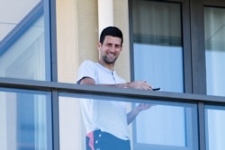Tennis star Novak Djokovic stands on his balcony at the accommodation where he is quarantining in advance of the Australian Open to be played in Melbourne, in North Adelaide, Australia, January 19, 2021. (AAP Image/Morgan Sette via REUTERS)