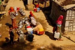 Women line up to fill containers with drinking water at the Rohingya refugee camp in Teknaf, Bangladesh on Feb. 12, 2020. (Hai Do/VOA)