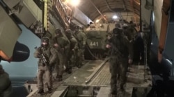 Russian service members disembark from a military aircraft, as part of a mission of the Collective Security Treaty Organization amid mass protests in Almaty and other Kazakh cities, at an airfield in Kazakhstan, in this still image from video released by Russia's Defence Ministry Jan. 8, 2022.