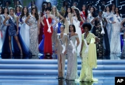 The final three contestants Miss South Africa Demi-Leigh Nel-Peters, Miss Colombia Laura Gonzalez, and Miss Jamaica Davina Bennett wait for the winner to be announced at the Miss Universe pageant Sunday, Nov. 26, 2017, in Las Vegas.