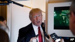President Donald Trump speaks with reporters on Air Force One while in flight from Andrews Air Force Base, Md., to Palm Beach International Airport, Florida, April 6, 2017.