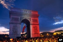 The Arc de Triomphe is lit up with the colors of the French national flag and by fireworks set off by French soccer fans celebrating France's World Cup victory over Croatia, in Paris, France, Sunday, July 15, 2018.