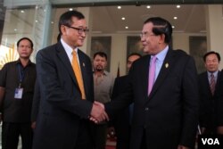 លោក​នាយក​រដ្ឋ​មន្រ្តី​ហ៊ុន​ សែន​ និង​លោក​សម​ រង្សី​ ប្រធាន​គណបក្ស​សង្គ្រោះ​ជាតិ​ ចាប់​ដៃ​គ្នា​នៅ​មុខរដ្ឋសភាជាតិ​ បន្ទាប់​ពី​ការ​បោះឆ្នោត​ផ្តល់​សេចក្តី​ទុក​ចិត្ត​គណៈកម្មាធិការ​ជាតិ​រៀបចំ​ការបោះឆ្នោត ​រាជធានី​ភ្នំពេញ​ ថ្ងៃ​ទី​៩​ ខែ​មេសា​ ឆ្នាំ​២០១៥។ (នូវ​ ពៅ​លក្ខិណា/VOA)