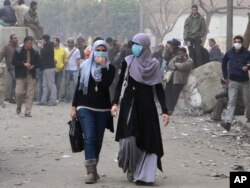 Misr inqilobida ayollar faol ishtirok etdi. Suratda Qohira ko'chalarida namoyishchilarga qarata otilgan ko'zdan yosh chiqaruvchi gazdan o'zini himoyalash maqsadida yuziga niqob taqib olgan ikki misrlik ayol aks etgan. 6-fevral, 2012-yil.