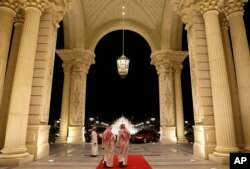 FILE - Saudi men walk at the entrance to the Ritz-Carlton Hotel, in Riyadh, Saudi Arabia, March 4, 2013. Dozens of elite detainees are reportedly being held in a well-guarded ballroom of the hotel as part of a sweeping corruption probe.