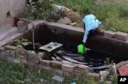 រូបឯកសារ៖ បុរស​ម្នាក់​កំពុង​ដង​ទឹក​ពី​អាង​ស៊ីម៉ង់ត៍​នៅ​ក្នុង​ទីក្រុង​ Bangalore ប្រទេស​ឥណ្ឌា។