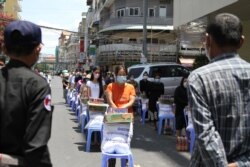 អាជ្ញាធរកំពុងផ្តល់ការឧបត្ថម្ភដល់ប្រជាពលរដ្ឋ ក្នុងសង្កាត់ផ្សារកណ្តាល១ ខណ្ឌដូនពេញ អំឡុងពេលបិទខ្ទប់នៅរាជធានីភ្នំពេញ និងក្រុងតាខ្មៅ ថ្ងៃទី២៦ ខែមេសា ឆ្នាំ២០២១។ (កាន់ វិច្ឆិកា/វីអូអេ)