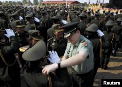A Chinese army advisor (C) puts rank on Cambodian army graduates during a graduation ceremony at Army Institute in Kampong Speu province March 12, 2015.