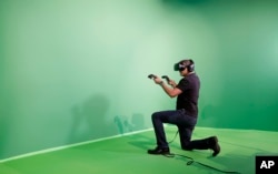 Liron Hadid plays a virtual reality video game during the Dell EMC World conference, Monday, May 8, 2017, in Las Vegas. (AP Photo/John Locher)