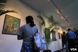 ទស្សនិកជន​មើល​រូប​គំនូរដែល​គូរ​ដោយ​លោក ឈឹម​ សុធី ជា​វិចិត្រករ​ដ៏​មាន​បទ​ពិសោធ​យូរ​ឆ្នាំ​ នៅក្នុង​ពិព័រណ៌​ «Consuming Passion»​ ក្នុង​សណ្ឋាគារ​ ក្នុង​រាជធានី​ភ្នំពេញ​ កាល​ពី​ថ្ងៃ​ទី​២៥​ ខែ​មិថុនា​ ឆ្នាំ​២០១៥។​ ពិព័រណ៌​គំនូរ​នេះ​អំពាវនាវ​ឲ្យ​មាន​ការថែរក្សា​បរិស្ថាន​និង​ធនធាន​ធម្មជាតិ​នៅ​ក្នុង​ប្រទេស​កម្ពុជា​ (នូវ​ ពៅ​លក្ខិណា/VOA)