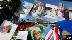 فائل - ڈیانا، ویلز کی شہزادی کی موت کی 20 ویں برسی کے موقع پر تصاویر اور جھنڈے 31 اگست، 2017 کو لندن میں کینسنگٹن پیلس کے دروازے پر اویزاں ہیں۔