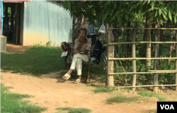 មេភូមិនៅស្រុកជីក្រែង ខេត្តសៀមរាប កំពុងអង្គុយមើលអ្នកទៅបោះឆ្នោត និងមានបញ្ជីឈ្មោះអ្នកបោះឆ្នោតនៅក្នុងដៃសម្រាប់គូសចំណាំអ្នកណាខ្លះបានទៅបោះឆ្នោត ឬមិនបានទៅបោះឆ្នោត កាលពីថ្ងៃទី២៩ ខែកក្កដា ឆ្នាំ២០១៩។ (ធីតា វីន/VOA)