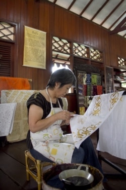 Turis Jepang Machiko Momoya mengoleskan lilin cair ke tekstil katun halus untuk menghasilkan desain figuratif pada kursus membatik di Museum Tekstil, Jakarta, pada 17 Maret 2012. (Foto: AFP/Oscar Siagian)