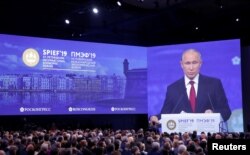Participants listen to Russian President Vladimir Putin as he delivers a speech during a session of the St. Petersburg International Economic Forum (SPIEF), Russia, June 7, 2019.