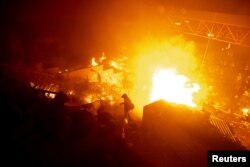 香港理工大學的抗議者站在燃燒的大火旁。 （2019年11月18日）