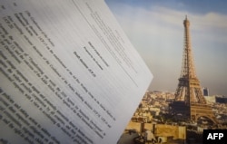 An illustration picture taken on Dec. 10, 2015 in Paris shows a draft for the outcome of the COP21 United Nations conference on climate change next to a picture of the Eiffel Tower.