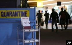 Passengers walk past the medical quarantine area showing information sheets on Middle East respiratory syndrome (MERS) at the arrivals section of Manila's International Airport in Paranaque, south of Manila, April 16, 2014.