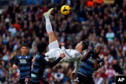 FILE - Real Madrid's Cristiano Ronaldo, of Portugal, top, tries to score in between opposition players during a Spanish La Liga soccer match between Real Madrid and Granada at the Santiago Bernabeu stadium in Madrid, Spain, Jan. 25, 2014.