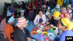 រូបឯកសារ៖ កម្មករ​រោងចក្រ​កាត់​ដេរ​សម្លៀកបំពាក់​កម្ពុជា​កំពុង​ទទួល​ទាន​អាហារ​ពេល​ថ្ងៃ​ត្រង់​នៅ​តូប​លក់​ម្ហូប​អាហារ​មួយ នៅ​ខាង​មុខ​រោងចក្រ​ដែល​ពួកគេ​ធ្វើការ ភ្នំពេញ ថ្ងៃទី៨ ខែឧសភា ឆ្នាំ២០១៤។