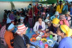 រូបឯកសារ៖ កម្មករ​រោងចក្រ​កាត់​ដេរ​សម្លៀកបំពាក់​កម្ពុជា​កំពុង​ទទួល​ទាន​អាហារ​ពេល​ថ្ងៃ​ត្រង់​នៅ​តូប​លក់​ម្ហូប​អាហារ​មួយ នៅ​ខាង​មុខ​រោងចក្រ​ដែល​ពួកគេ​ធ្វើការ ភ្នំពេញ ថ្ងៃទី៨ ខែឧសភា ឆ្នាំ២០១៤។