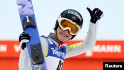 Coline Mattell of France smiles after her jump during the women's Normal Hill Individual jumping competition at the FIS Nordic Skiing World championships in the northern mountain resort of Predazzo in Val di Fiemme, Feb. 22, 2013.
