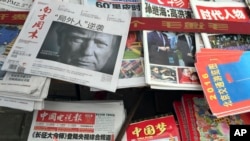 FILE - front page of a Chinese newspaper with a photo of U.S. President-elect Donald Trump and the headline "Outsider counter attack" is displayed at a newsstand in Beijing, China.