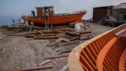 Boatbuilders work at a boat building area in Karlovasi, Samos Island, Greece, on Friday, June 11, 2021. The Greek island of Samos was once a major production center of traditional wooden boats. (AP Photo/Petros Giannakouris)