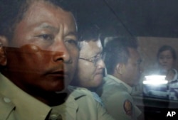 រូបឯកសារ៖ លោក នី ចរិយា (កណ្តាល) អតីត​មន្ត្រី​របស់​អង្គការ​អាដហុក និង​ជា​សមាជិក​ម្នាក់​នៃ​គណៈកម្មាការ​រៀបចំ​ការ​បោះឆ្នោត កំពុង​ត្រូវបាន​បញ្ចូន​ខ្លួន​ទៅ​អង្គភាព​ប្រឆាំង​អំពើ​ពុក​រលួយ​ បន្ទាប់​ពី​បាន​ចូលបង្ហាញ​ខ្លួន នៅ​សាលាដំបូង​រាជធានី​ភ្នំពេញ កាលពី​ថ្ងៃទី៣០ ខែមេសា ឆ្នាំ២០១៦។ (AP Photo/Heng Sinith)