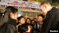 2005年3月25日，上海，年輕的中國學生在露天英語角與外國人練習英語。