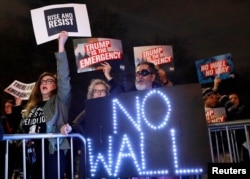 People gather during a protest against U.S. President Donald Trump's declaration of a national emergency to build a border wall, outside Trump International Hotel & Tower in Manhattan, New York, U.S. February 15, 2019.