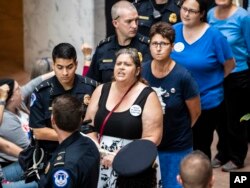 Protesters opposed to President Donald Trump's Supreme Court nominee, Brett Kavanaugh, are arrested outside the office of Judiciary Committee Chairman Chuck Grassley, R-Iowa, in the Hart Senate Office Building on Capitol Hill in Washington, Sept. 20, 2018