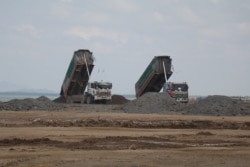 Trucks dump sand into a filling site in Kep coastal province, Cambodia, Dec. 27, 2021. (Sun Narin/VOA Khmer)