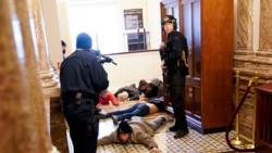 ប៉ូលិស​ការពារ​វិមាន​សភា​សហរដ្ឋ​អាមេរិក​ភ្ជង់កាំភ្លើង​ទៅ​ក្រុម​បាតុករ នៅ​ក្បែរ​សាល​ប្រជុំក្នុង​វិមាន​សភា រដ្ឋធានី​វ៉ាស៊ីនតោន ថ្ងៃទី៦ ខែមករា ឆ្នាំ២០២១។