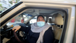 Palestinian woman Naela Abu Jibba, who started a women-only taxi service in the Gaza Strip, sits behind the wheel of her vehicle at Beach refugee camp in Gaza City on November 17, 2020. (REUTERS/Mohammed Salem)