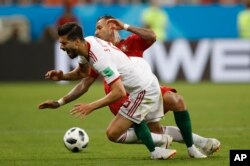 El frente de Saeid Ezatolahi de Irán cae cuando es abordado por el portugués Ricardo Quaresma durante el partido del grupo B entre Irán y Portugal en la Copa Mundial de fútbol 2018 en el Mordovia Arena en Saransk, Rusia, el lunes 25 de junio de 2018.