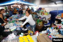 Mehana Kihoi hands out goods to Leilani Estate evacuees at the community organized Pu'uhonua o Puna, a center to help those affected by the recent lava eruption, in Pahoa, Hawaii, May 29, 2018.