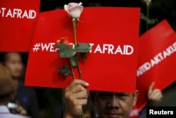 People hold placards reading "We are not afraid" during a rally at the scene of Thursday's gun and bomb attack in central Jakarta, Indonesia, Jan. 15, 2016.