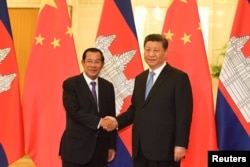 រូបឯកសារ៖ លោកនាយករដ្ឋមន្ត្រី ហ៊ុន សែន ចាប់ដៃ​ជាមួយ​លោក​ប្រធានាធិបតីចិន ស៊ី ជីនពីង មុន​កិច្ចប្រជុំនៅវិមានរដ្ឋាភិបាលចិនប្រចាំទីក្រុង​ប៉េកាំង ប្រទេស​ចិន ថ្ងៃទី២៩ ខែមេសា ឆ្នាំ២០១៩។